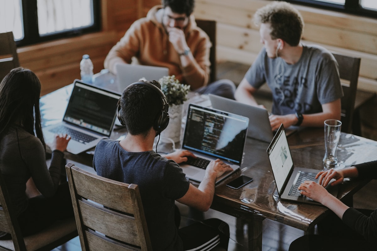 Team discussing work around a table with screens